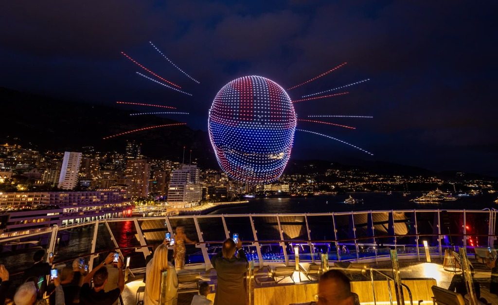 An illuminated racing helmet formed by drones above Monaco